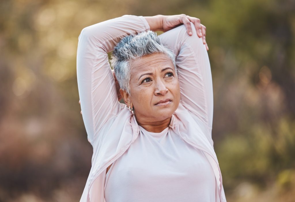 Fitness, stretching or old woman in nature thinking of body goals starts training, exercise or work