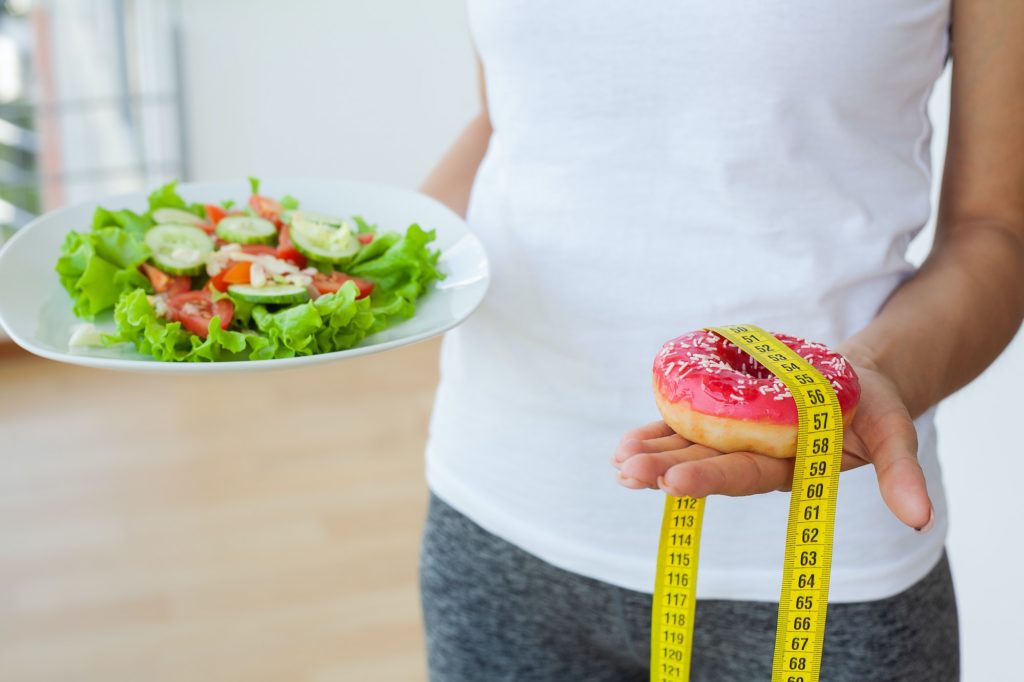 Woman makes a choice between harmful and healthy foods